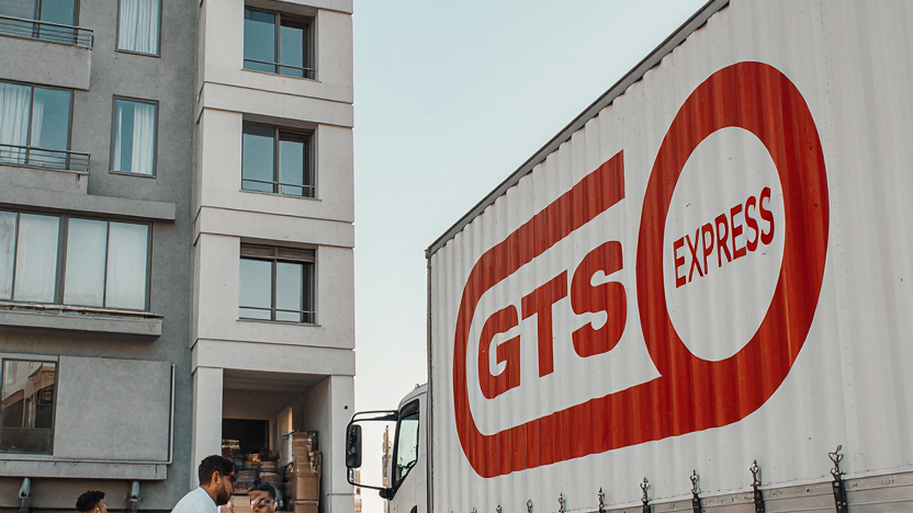 Cena-realista-de-um-caminhao-de-mudancas-moderno-branco-com-logo-Gts-Express-em-vermelho-container_0